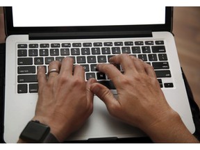 A person works on a laptop in North Andover, Mass., June 19, 2017 file photo. Statistics Canada says Canadian businesses reported spending $14 billion on cybersecurity in 2017 as they confront greater digital risks.