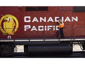 A Canadian Pacific Railway employee walks along the side of a locomotive in a marshalling yard in Calgary, Wednesday, May 16, 2012. Canadian Pacific Railway Ltd. says it notched the biggest profits of its 137-year history last quarter, bolstering a balance sheet that suffered earlier this year from service interruptions tied to labour action.