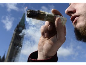 A man smokes a marijuana joint during the annual 4/20 marijuana celebration on Parliament Hill in Ottawa on Friday, April 20, 2018. The illegal production and consumption of non-medical cannabis was worth about $3.3 billion in 2016, according to Statistics Canada's most recent analysis of the underground economy.