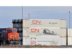A CN locomotive passes by freight containers at the CN Taschereau yard in Montreal on November 28, 2009.
