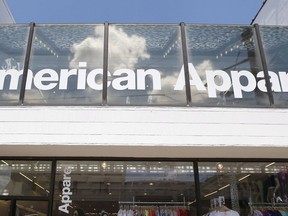 Passers-by walk down the street past the American Apparel store in the Shadyside neighborhood of Pittsburgh on Wednesday, July 9, 2014. One of America's most controversial clothing brands is making a comeback, but ditching some of its signature traits. American Apparel will return to the Canadian market with an online store on Nov 1., a year after its bankruptcy and closure.