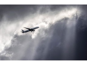 An Air Canada plane flies underneath dark clouds illuminated by some sun rays above Frankfurt, Germany, Thursday, March 2, 2017. The legalization of recreational marijuana next week is reopening old wounds and sparking new battles between employers and employees in high-risk jobs that could wind up in the court system. A recent decision by Air Canada to prohibit all employees in flight operations and aircraft maintenance from using cannabis at all times, both on-duty and off-duty, has raised eyebrows on both sides of the debate.