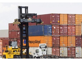 Containers are unloaded at the Port of Montreal in Montreal on July 20, 2017. The Canada Border Services Agency and the Port of Montreal are dipping their feet into a blockchain-powered technology that aims to streamline freight shipping and cut costs. In a trial run, the federal customs agency and the country's second-biggest port have signed on to the digital database -- a distributed ledger that shares and syncs up data from carriers, ports and wholesalers in places from Singapore to Peru.