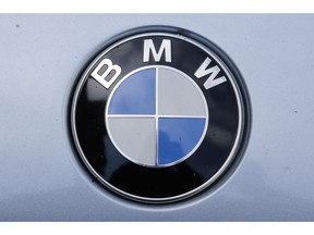 FILE - In this Aug. 1, 2017 file photo the brand logo of German car maker BMW is photographed on a car in Berlin. BMW said it is expanding a recall to cover 1.6 million vehicles worldwide due to possible fluid leaks that could result in a fire.