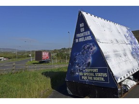 In this photo taken on Wednesday, Oct. 10, 2018, a sign in a parking lot of a cemetery reads: "No EU border in Ireland" near Carrickcarnan, Ireland, just next to the Jonesborough Parish church in Northern Ireland. The land around the small town of Carrickcarnan, Ireland is the kind of place where Britain's plan to leave the European Union walks right into a wall - an invisible one that is proving insanely difficult to overcome. Somehow, a border of sorts will have to be drawn between Northern Ireland, which is part of the United Kingdom, and EU member country Ireland to allow customs control over goods, produce and livestock once the U.K. has left the bloc.