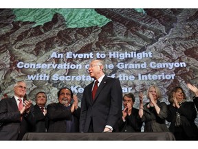 File - In this Jan. 9, 2012 file photo, then Interior Secretary Ken Salazar, center, standing in front of a map of the Grand Canyon, is applauded after announcing a twenty year ban on new mining claims near the Grand Canyon in Washington. The U.S. Supreme Court has denied review of an Obama-era action that put nearly 1 million acres near the Grand Canyon off-limit to new mining claims. Environmentalists hailed the decision Monday, Oct. 1, 2018, but say they're worried the Trump administration is working to end the ban administratively.