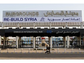 In this Tuesday, Oct. 2, 2018 photo, Chinese visitors arrive to the opening of the Syria rebuilding exhibition at the fair grounds in Damascus, Syria. With back-to-back trade fairs held in Damascus this month, Syria hopes to jumpstart reconstruction of its devastated cities by inviting international investors to take part in lucrative opportunities.