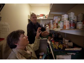 Volunteers Elizabeth and David gather food items from a checklist to give to a family from a foodbank at the Ivybridge estate community centre in west London, Thursday, Oct. 25, 2018. Much of Britain will continue to feel the effects of eight years of spending cuts, even after the government's Treasury chief heralded the end of austerity by splashing out billions of pounds for health, transportation and small business in his latest budget.