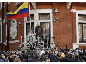 FILE - In this file photo dated Friday May 19, 2017, watched by the media WikiLeaks founder Julian Assange looks out from the balcony of the Ecuadorian embassy prior to speaking, in London.  Newly released Ecuadorean government documents made public late Tuesday Oct. 16, 2018, by Ecuadorean opposition lawmaker Paola Vintimilla, have laid bare an unorthodox attempt to extricate the WikiLeaks founder from his embassy hideaway in London by naming him as a political counselor to the country's embassy in Moscow.