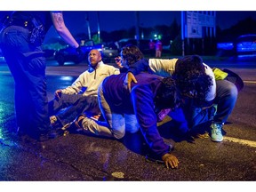 People gather to tend to protesters after several people were hospitalized when a truck collided with into protesters calling for the right to form unions Tuesday, Oct. 2, 2018, in Flint, Mich. Police said the collision appears to be an accident.