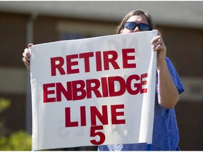 FILE - In this July 6, 2017, file photo, Lauren Sargent, takes part in a protest before the Enbridge Line 5 pipeline public information session in Holt, Mich. Officials tell The Associated Press that Michigan Gov. Rick Snyder's administration and Canadian pipeline giant Enbridge have reached a deal on replacing 65-year-old twin pipelines in a channel linking two of the Great Lakes. An announcement was scheduled for Wednesday Oct. 3, 2018. Officials tell the AP the agreement calls for shutting down the Line 5 pipes in the Straits of Mackinac connecting Lakes Huron and Michigan.