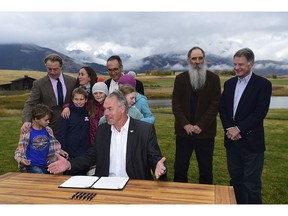 U.S. Interior Secretary Ryan Zinke, center, is surrounded by residents, business people and family members as he signs a 20-year mining moratorium on lands in Paradise Valley, Mont. on Monday, Oct. 8, 2018 at Sage Resort in Pray, Mont.  Zinke approved a 20-year ban on new mining claims in the mountains north of Yellowstone National Park after two proposed gold mines raised concerns the area could be spoiled.