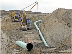 FILE - In this Oct. 5, 2016, file photo, heavy equipment is seen at a site where sections of the Dakota Access pipeline were being buried near the town of St. Anthony in Morton County, N.D. On Friday, Oct. 19, 2018, Texas-based Energy Transfer Partners, the developer of the pipeline, began seeking commitments from shippers to transport additional oil through the pipeline from 500,000 barrels to 570,000 barrels per day, despite ongoing tribal efforts to shut the pipeline down.