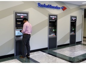FILE- In this July 9, 2018, file photo a customer makes a transaction at a Bank of America ATM at the company's headquarters in Charlotte, N.C. Bank of America Corp. reports earnings Monday, Oct. 15.