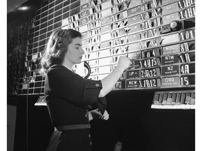 FILE- In this Sept. 6, 1947, file photo Dolores Hennessy, bulletin clerk in the quotation department, changes bid and asked prices on the information relayed to her from the central tube room in New York. The lettered cards carry symbols for Curb Exchange stock issues while the numbered cards show the current market in those issues. The S&P 500, the stock market's benchmark index, has climbed in the 12 months after each of the midterm elections going back to 1946. That's 18 elections, many of which ended up shuffling the balance of power in Congress.