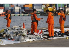 FILE- In this Monday, Oct. 29, 2018, file photo members of Indonesian Search and Rescue Agency (BASARNAS) inspect debris recovered from near the waters where a Lion Air passenger jet is suspected to crash, at Tanjung Priok Port in Jakarta, Indonesia. A Lion Air flight crashed into the sea just minutes after taking off from Indonesia's capital on Monday. The deadly crash has renewed questions about the safety of Indonesian airlines soon after U.S. and European regulators removed prohibitions against them.