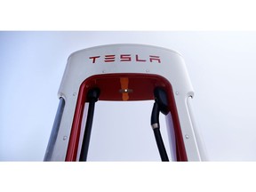 FILE- In this Aug. 24, 2018, file photo a Tesla vehicle Supercharging station in Seabrook, N.H. Tesla made its biggest gain in five years Monday, Oct. 1, after company founder Elon Musk reached a settlement with securities regulators that will allow him to stay CEO of the electric car maker. That marked a big reversal from Friday's plunge, the worst day for the stock in almost as long.