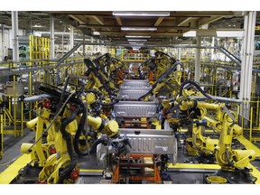 FILE- In this Sept. 27, 2018, file photo robots weld the bed of a 2018 Ford F-150 truck on the assembly line at the Ford Rouge assembly plant in Dearborn, Mich. On Tuesday, Oct. 16, the Federal Reserve reports on U.S. industrial production for September.