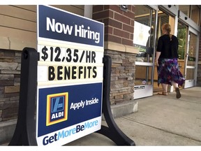 FILE- In this July 17, 2018, file photo, a sign outside a business in Salem, N.H. says "Now Hiring." On Tuesday, Oct. 16, the Labor Department reports on job openings and labor turnover for August.