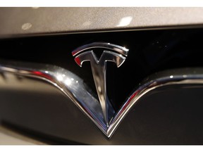 FILE- This Oct. 3, 2018, file photo shows a Tesla emblem at the Auto show in Paris. Shares of Tesla Inc. soared Tuesday, Oct. 23, a day ahead of the company's third-quarter earnings release.