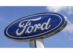 FILE - This Jan. 17, 2017, file photo shows a Ford sign at an auto dealership, in Hialeah, Fla. U.S. safety regulators are trying to figure out why the power tailgates on some Ford F-Series pickup trucks can open unexpectedly while the trucks are moving. The National Highway Traffic Safety Administration opened an investigation into F-250 and F-350 Super Duty trucks from the 2017 model year.