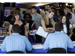 FILE- In this June 21, 2018 file photo, job applicants talks with representatives from Aldi at a job fair hosted by Job News South Florida, in Sunrise, Fla. On Wednesday, Oct. 31, payroll processor ADP reports how many jobs private employers added in October.