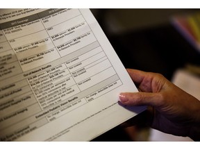 FILE - In this Monday, Dec. 4, 2017, file photo, a person looks over her health insurance benefit comparison chart which shows out-of-network coverages dropped for 2018 in Peachtree City, Ga. The Kaiser Family Foundation finds that more companies are making workers pay an annual deductible or increasing the amount they must spend before insurance starts covering most care.