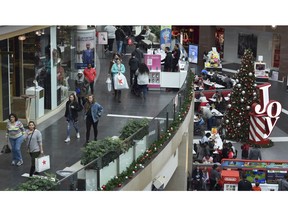 FILE- In this Dec. 22, 2017, file photo people shop at the Pentagon City Mall in Arlington, Va. The National Retail Federation, the nation's largest retail trade group, says it expects sales in November and December to rise as shoppers continue to be in a spending mood in a stronger economy.