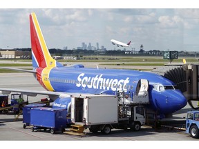 FILE- In this July 17, 2018, file photo ramp workers prepare a Southwest Airlines Boeing 737 for departure to Denver from Minneapolis International Airport in Minneapolis. Southwest Airlines Co. reports earnings Thursday, Oct. 25.