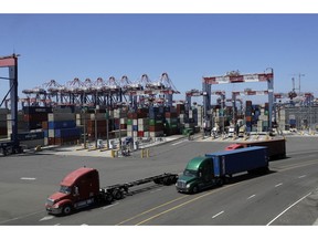 FILE- In this Aug. 22, 2018, file photo trucks travel along a loading dock at the Port of Long Beach in Long Beach, Calif. On Friday, Oct. 26, the Commerce Department issues the first of three estimates of how the U.S. economy performed in the third quarter.