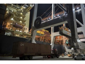 In this July, 5, 2018 photo, a post-Panamax crane loads a 40-foot shipping container onto a container ship at the Port of Savannah in Savannah, Ga. On Friday, Oct. 5, the Commerce Department reports on the U.S. trade gap for August.