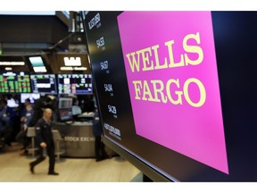 FILE- In this May 17, 2018, file photo the logo for Wells Fargo appears above a trading post on the floor of the New York Stock Exchange. Wells Fargo reports earnings Friday, Oct. 12, 2018.
