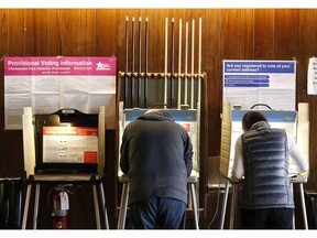 FILE - In this Nov. 8, 2016, file photo, residents of Chicago' 33rd Ward mark their ballots at Marie's Golden Cue pool hall. A security lapse last year by voting system vendor Election Systems & Software publicly exposed data on Chicago's 1.8 million voters for months online. The lapse provided a rare moment of public accountability for a closely held business that is a front-line guardians of U.S. election security.