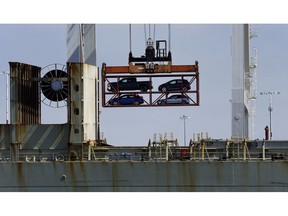 FILE - In this July 13, 2017, file photo, a crane transporting vehicles operates on a container ship at the Port of Oakland, in Oakland, Calif. Vehicle sales are slowing down despite a run on big SUVs. Major automakers said Tuesday, Oct. 2, 2018, that U.S. sales fell 7 percent in September and 4 percent for the June-through-September quarter, compared with the same periods last year.