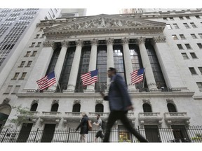 FILE - In this June 24, 2016, file photo, people walk by the New York Stock Exchange. On Monday, Oct. 1, 2018, stocks are opening broadly higher on Wall Street, led by big gains in industrials after General Electric named a new CEO.