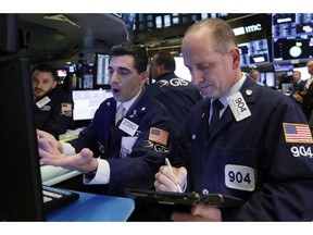 FILE- In this Oct. 23, 2018, file photo specialist Peter Mazza, center, and trader Michael Urkonis work on the floor of the New York Stock Exchange. The U.S. stock market opens at 9:30 a.m. EDT on Wednesday, Oct. 31.