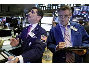 FILE- In this Oct. 11, 2018, file photo trader Peter Mazza, left, works with trader Daniel Trimble on the floor of the New York Stock Exchange. The U.S. stock market opens at 9:30 a.m. EDT on Thursday, Oct. 18.