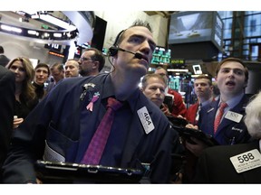 Trader Gregory Rowe, left, works on the floor of the New York Stock Exchange, Thursday, Oct. 25, 2018. Strong results from major companies including Microsoft, Visa and Comcast are sending U.S. stocks higher Thursday morning as the market found its footing after three weeks of steep declines.