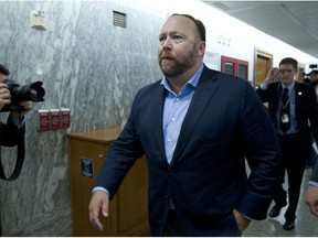 FILE - In this Wednesday, Sept. 5, 2018, file photo, Alex Jones, the right-wing conspiracy theorist, walks the corridors of Capitol Hill after listening to testimony on Capitol Hill in Washington. On Tuesday, Oct. 23, 2018, Twitter confirmed it has removed accounts linked to conspiracy-monger Alex Jones and Infowars.