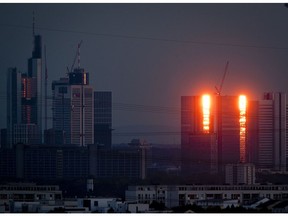 The towers of the Deutsche Bank are illuminated by the setting sun in Frankfurt, Germany, Sunday, Sept. 30, 2018.