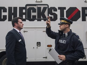 Cpl. Richard Nowak demonstrates existing cannabis-testing techniques on communications manager Fraser Logan in Edmonton.