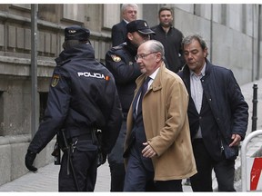 FILE - In this Dec. 20, 2012 file photo, former IMF managing director Rodrigo Rato, center right, arrives at the National Court in Madrid, Spain. Rato is apologizing for his crimes as he starts a 4½-year prison sentence for misusing a Spanish bank's corporate credit card as he entered a prison outside Madrid on Thursday Oct. 25, 2018.