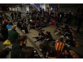 Activists advocating for Catalan secession sit on the railway tracks at the station in Girona, Spain, Monday Oct. 1, 2018. Activists blocked major highways, train lines and avenues across the northeastern region one year after a banned referendum crushed by police failed to deliver an independent state.