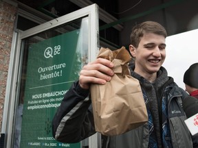 A young man holds a bag of marijuana he bought in a cannabis store in Quebec City, Quebec on Oct. 17, 2018.