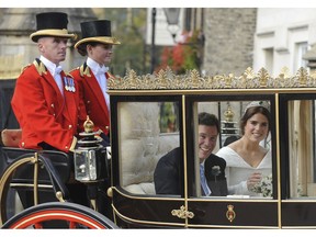 Princess Eugenie of York, right, and Jack Brooksbank smile as they travel from St George's Chapel to Windsor Castle after their wedding at St George's Chapel, Windsor Castle, near London, England, Friday, Oct 12, 2018.