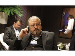 FILE - In this Jan. 29, 2011, file photo, Saudi Arabian journalist Jamal Khashoggi speaks on his cellphone at the World Economic Forum in Davos, Switzerland. The Washington Post said Wednesday, Oct. 3, 2018, it was concerned for the safety of Khashoggi, a columnist for the newspaper, after he apparently went missing after going to the Saudi Consulate in Istanbul.