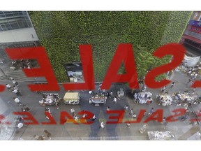 FILE - In this July 26, 2016, file photo, sale signs are displayed on a window of a store at a shopping district in Seoul, South Korea. South Korea reported on Thursday, Oct. 25, 2018, that its economy grew at a slower annual pace during the July-September period as slumping domestic investment negated modest gains in consumption and exports.