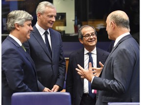 Italian Finance Minister Giovanni Tria, second right, speaks with French Finance Minister Bruno Le Maire, second left, and European Commissioner for Economic and Financial Affairs Pierre Moscovici during a round table meeting of eurogroup finance ministers at the European Council building in Luxembourg, Monday, Oct. 1, 2018.