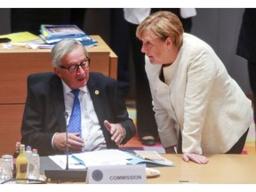 German Chancellor Angela Merkel, right, speaks with European Commission President Jean-Claude Juncker during a round table meeting at an EU summit in Brussels, Thursday, Oct. 18, 2018. EU leaders meet for a second day on Thursday to discuss migration, cybersecurity and to try and move ahead on stalled Brexit talks.