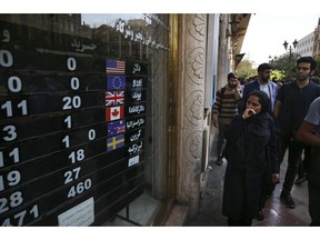 FILE - In this Oct. 2, 2018, file photo, an exchange shop displays rates for various currencies, in downtown Tehran, Iran. A battle is brewing between the Trump administration and some of the president's biggest supporters in Congress who are concerned that sanctions to be re-imposed on Iran early next month won't be tough enough.